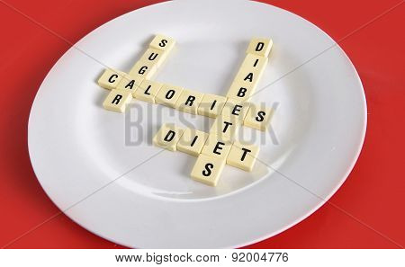 Crossword Game On Dish On Table Red Mat With Words Sugar , Calories, Diabetes And Diet Taking In Sug