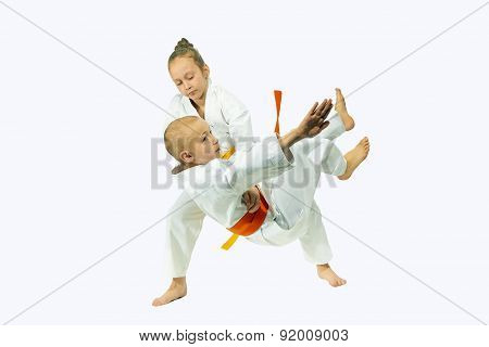 In judogi the little sportswoman is training throw