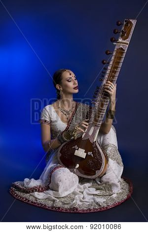 Beautiful Indian Woman In Sari With Oriental Jewelry Playing The Sitar