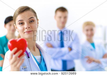 Female doctor with stethoscope holding heart.