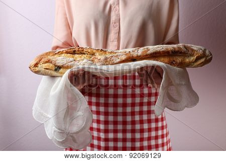 Woman holding tasty fresh bread, close up