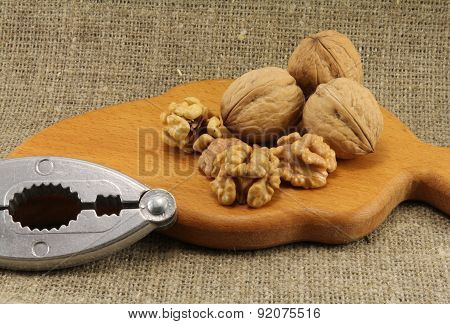 Walnuts On A Wooden Board (cutting Board) With A Nutcracker