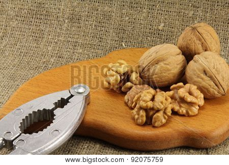 Walnuts On A Wooden Board (cutting Board) With A Nutcracker