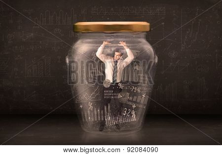 Businessman traped in jar with graph chart symbols concept on background