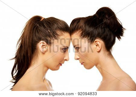 Two attractive sisters standing face to face.