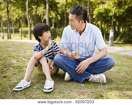 Asian Father And Son Having A Conversation
