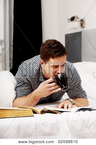 Handsome thoughtful man with a book in his bed.