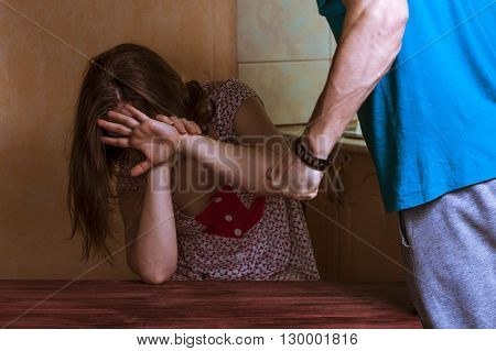 Woman covering her face in fear of domestic violence. Aggression in the family.