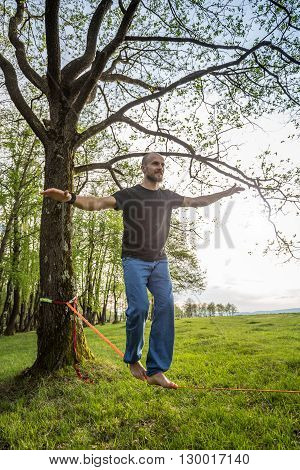 Young man slacklining in a forest, outdoor shot