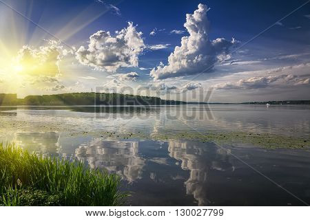 scenic lake in the summer park. Dramatic blue sky. Cloudscape
