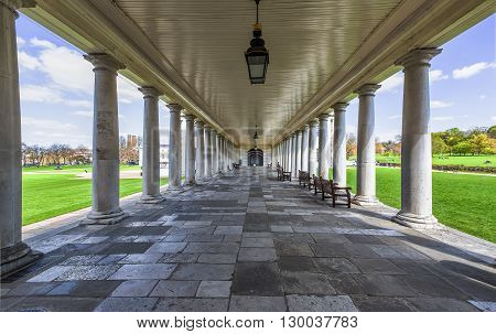 Colonnade into indefinite with benches in a park