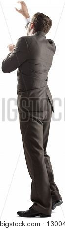 Rear view of young business man pointing at copy space isolated over white background. Full length portrait of businessman standing back
