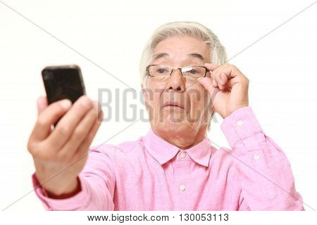senior Japanese man with presbyopia on white background