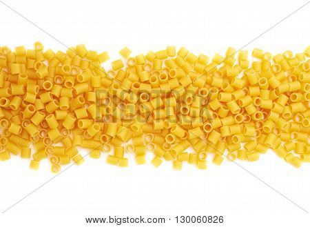 Line made of dry ditalini yellow pasta over isolated white background