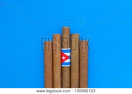 Detail of luxury Cuban cigars on the blue desk