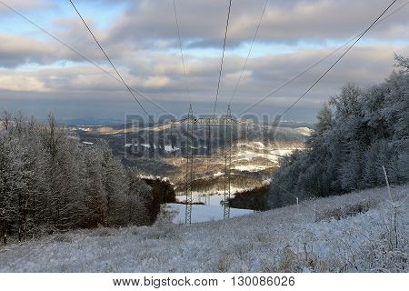 Electric posts in snow mountains in north Bohemia