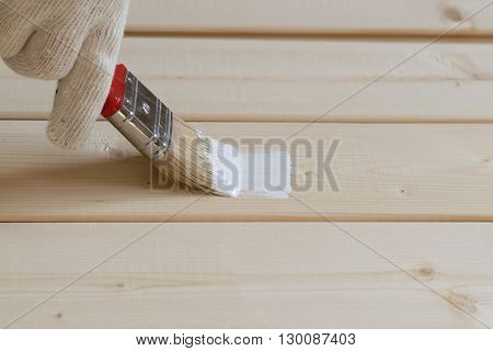 painting with white paint the wooden lining of pine