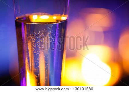 Close-up of candlelit glass with sparkling champagne. Love celebration relax romance luxurious vacation wellness spa concept.