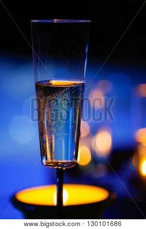 Extravagant private romantic candlelit champagne glass with a  in the background. Love celebration relax romance luxurious vacation wellness spa concept.