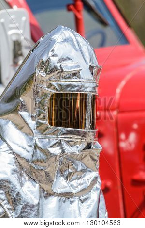 Firemana in special heat resistant suit on a background of fire engine