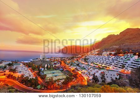 Puerto de Santiago at sunset time, panoramic view over vibrant architecture, in Tenerife Spain.