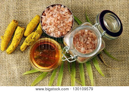 Healthy ingredients of Honey Turmeric root and pink Himalayan sea salt on a burlap cloth.
