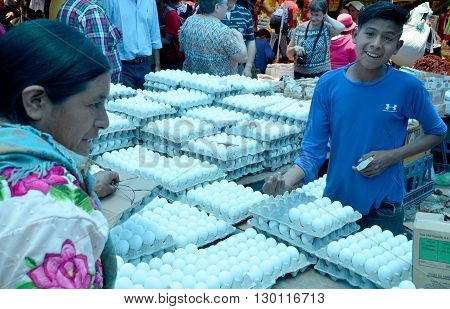 QUETZALTENANGO GUATEMALA APRIL 28 2016 : Young man sale eggs in Quetzaltenango maket. This native market is the most colorful in Central America