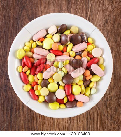 Colorful medical pills tablets capsules or supplements for therapy on plate concept of treatment and health care