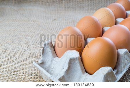 Chicken eggs in box brown eggs on sackcloth background with copy space
