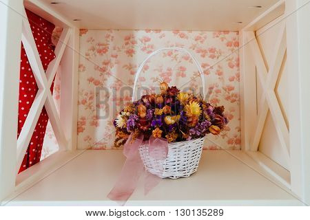 Beautiful shelves with dried meadow flowers in a basket