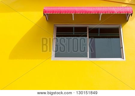 Window on yellow wall with red splash board