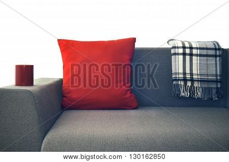 red pillow and a plaid on a gray couch