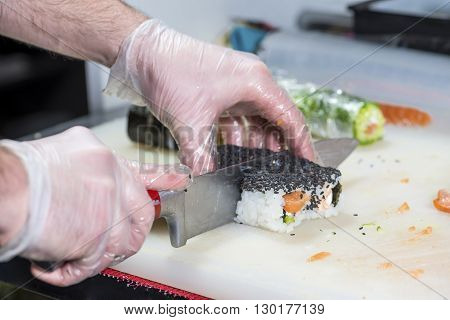 closeup of chef preparing sushi in the kitchen shallow DOF
