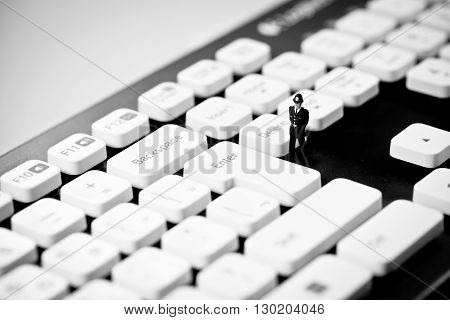 Miniature Police officer on top of computer keyboard. Internet piracy and criminality cpncept.