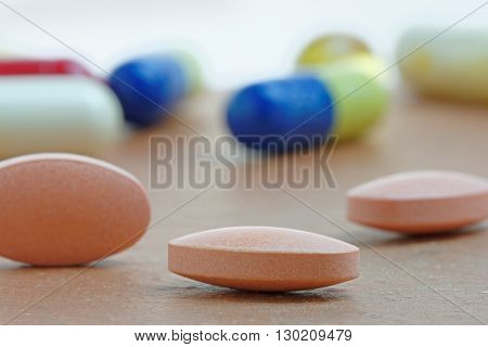 Close up of statin tablet or generic pill with out of focus tablets in background