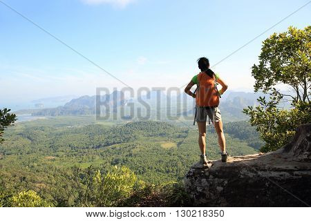 successful woman hiker enjoy the view on mountain top