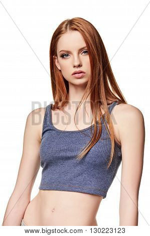 Slim teen girl in short top standing over white background