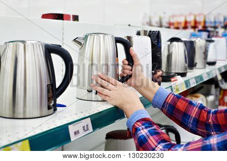 Woman housewife shopping for the electric kettle