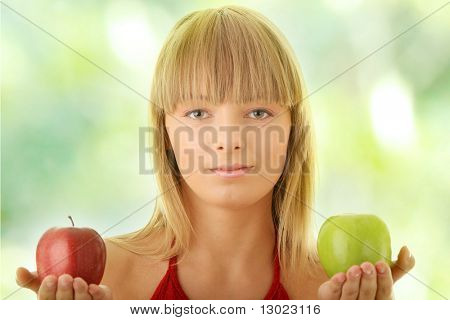 Jeune femme blonde avec des pommes rouges et vertes sur la main - faire décision concept