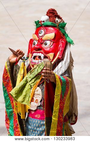 Unidentified monk with phurpa (ritual knife) performs a religious masked and costumed mystery dance of Tibetan Buddhism during the Cham Dance Festival in Hemis monastery, India.