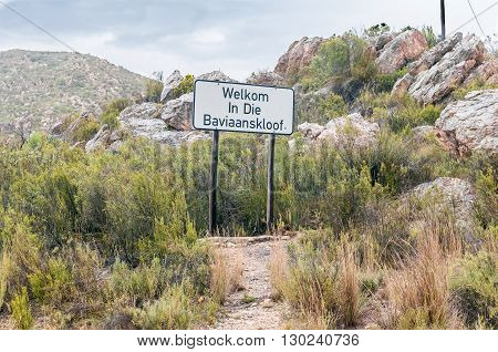 Welcome sign at the western entrance of a wet and gloomy Baviaanskloof (baboon valley) during a rain storm