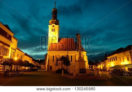 Night view of Jurisics square in Koszeg with Maria statue and St. Imre church Hungary.