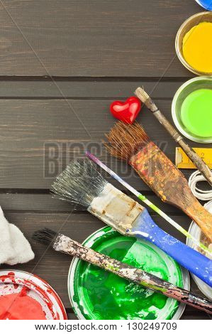 Brushes and paint on a wooden table. Painter tools. Workshop painter. Needs painting. Sales painting needs. Clutter on the workbench. Sales of color. Advertising on painting.