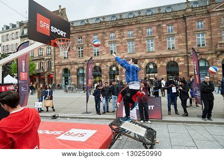STRASBOURG FRANCE - MAY 14 2016: Young boy jumping to throw the basket ball in the center of Strasbourg during SFR Telecom presentation
