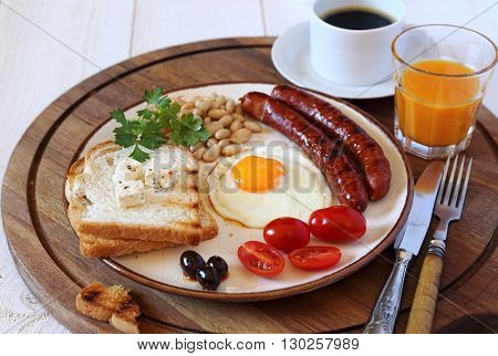 English breakfast with sausage fried egg baked beans and coffee