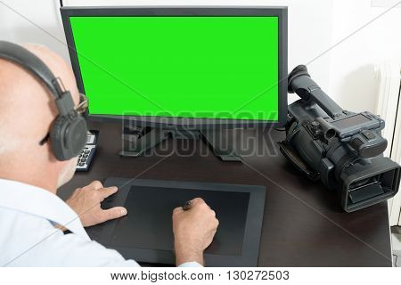 a mature man video editor in his studio