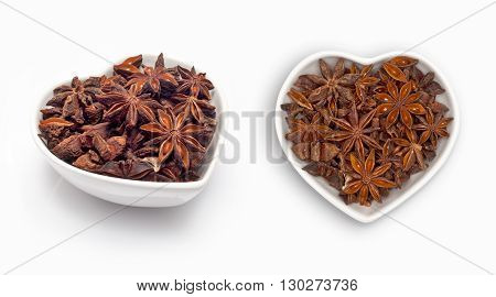 Star anise  in a heart shaped bowl, isolated on white