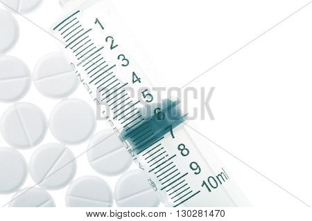 Siringe and pills isolated on white background.