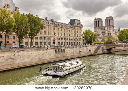 PARIS, FRANCE - JUNE 1, 2015 Tour Boat Seine River Notre Dame Spires Towers Bridge Overcast Skies Notre Dame Cathedral Paris France. Notre Dame was built between 1163 and 1250 AD.