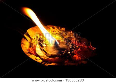 Burning pooja candle at night on the river Ganges Varanasi India